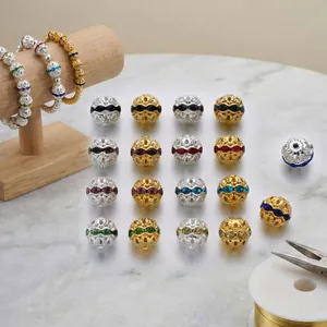 Detalle de cuentas espaciadoras huecas de 10mm en oro y plata con cristales de colores.