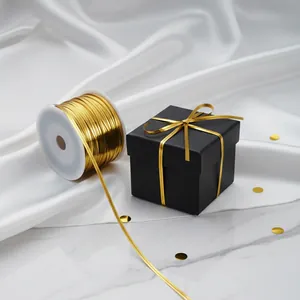 Close-up detail of shiny gold PET metallic twist ties decorating a matte black gift box