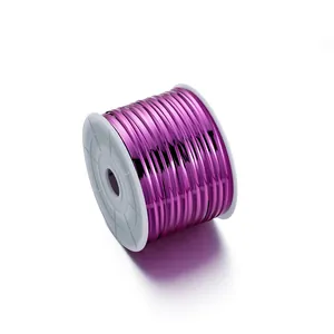 Detailed view of shiny metallic purple PET twist ties on a white plastic spool holder