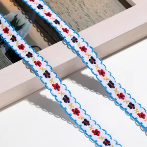Nahaufnahme von bunt besticktem Blumenband mit blauem Wellenrand für Handwerk
