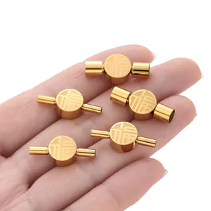 Detail view of gold stainless steel Fu character clasps for DIY jewelry connectors.
