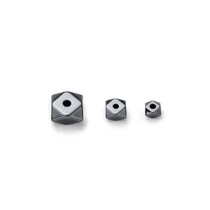 Detail view of geometric faceted hematite beads in three varying sizes for DIY jewelry