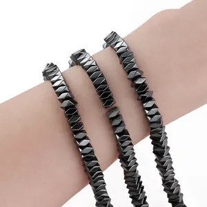 Close-up of black geometric hematite beads for DIY jewelry making on wrist.