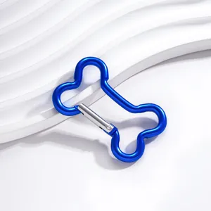 Gros plan d'un mousqueton en aluminium bleu en forme d'os sur un fond blanc très épuré.