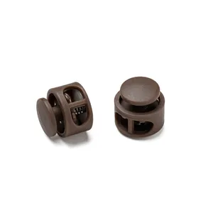 Detailed close-up view of two brown plastic double-hole cord lock toggles with internal spring