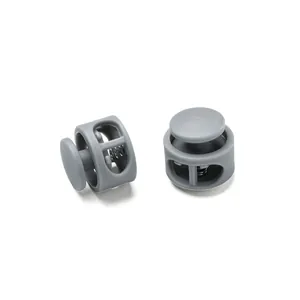 Detail view of gray plastic double-hole cord locks with internal metal spring