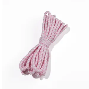 Détail macro d'un cordon en coton tressé bicolore rose et blanc pour artisanat
