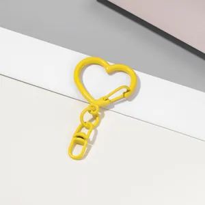 Gros plan d'un fermoir mousqueton jaune en forme de cœur avec une finition laquée