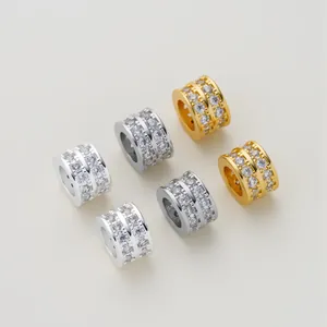 Detailed view of gold and silver barrel charms with double row cubic zirconia micro-pave.