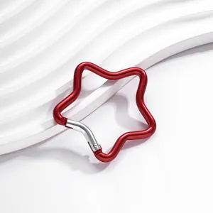 Détail d'un mousqueton en aluminium rouge en forme d'étoile avec un fermoir à ressort