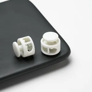 Detailed view of white double-hole plastic spring cord locks for drawstring adjustment