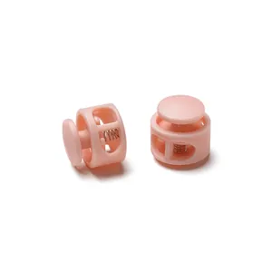 Close-up macro view of pink round double-hole plastic cord locks with internal spring
