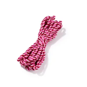 Gros plan sur une corde en coton torsadée rose et rouge pour DIY et les emballages.