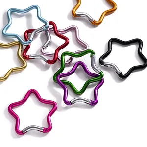 Gros plan de divers mousquetons colorés en alliage d'aluminium en forme d'étoile pour porte-clés