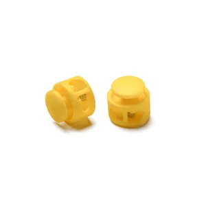 Detailed view of two yellow round double-hole plastic spring cord locks for drawstrings