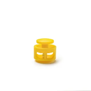 Close-up of yellow plastic round cord lock with double-hole spring toggle mechanism