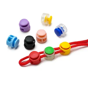 Detail shot of colorful double-hole plastic spring cord locks threaded on red rope