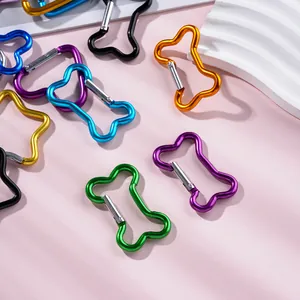 Gros plan de mousquetons en alliage d'aluminium en forme d'os pour porte-clés variés.