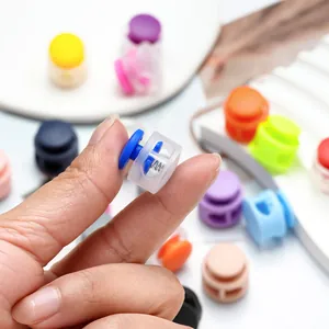 Macro detail of colorful plastic spring cord lock held by fingers showing spring
