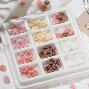 Nahaufnahme von Vintage-Mini-Resin-Rosen in einer weißen Palette für DIY-Nagelkunst