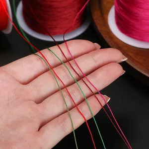 Gros plan détaillé de fils de jade colorés de 0,4 mm pour la création de bijoux.