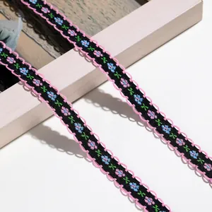 Detailaufnahme von schwarzem Blumen-Stickband mit rosa Wellenkanten
