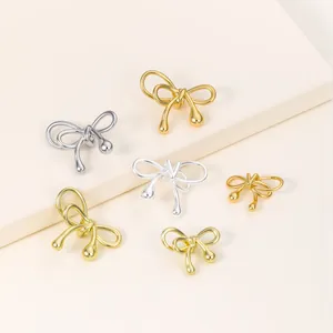 Macro view of gold and silver plated bow knot spacer beads for DIY jewelry design.