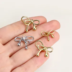 Detailed view of gold and silver bow charms with teardrop ends for DIY jewelry