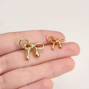 Detailed view of glossy gold-plated bow beads with teardrop ends for DIY jewelry crafting