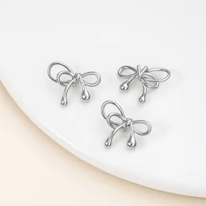 Detailed macro view of three glossy silver bow-shaped spacer beads with waterdrop tips