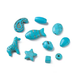 Vue détaillée de perles de turquoise synthétique en formes de poisson, étoile et girafe.