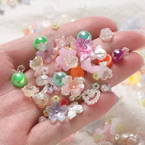 Close-up of mixed colorful acrylic flower and round beads for DIY jewelry and nail art.