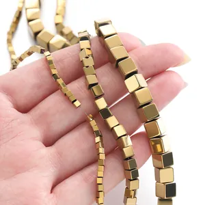 Macro detail of golden hematite cube beads in four different sizes for DIY jewelry making.