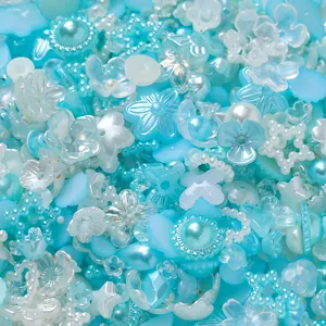 Close-up of mixed cyan and pearl acrylic beads for DIY nail art and jewelry.