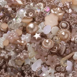 Detail view of champagne and cream acrylic beads in various flower and star shapes