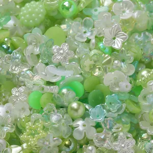 Macro view of mixed green and iridescent acrylic beads in petal and round shapes