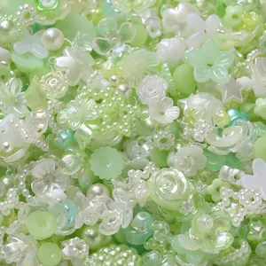 Close-up of mixed light green and white acrylic beads with flower and star shapes