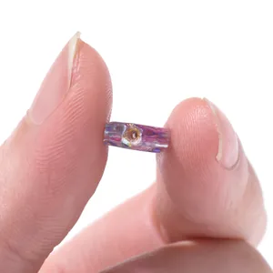 Primo piano di perla ovale in vetro ceco viola iridescente 9,5x20mm per gioielli fai-da-te.