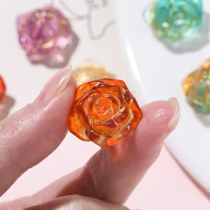 Close-up of a translucent orange rose bead with gold accents for DIY jewelry making.