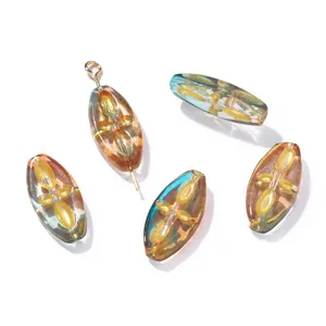 Primo piano di perle ovali in vetro ceco 9,5x20mm con trama a foglia d'oro.