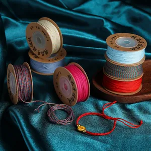 Gedetailleerd overzicht van 1mm kleurrijke katoenen koord spoelen met gevlochten armband
