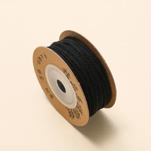 Macrodetail van 1mm zwart katoenen koord op kraft karton voor DIY sieraden maken