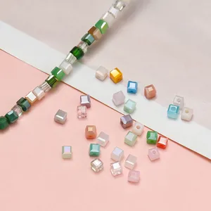 Primo piano di perline di vetro a cubo macaron colorate per la creazione di gioielli