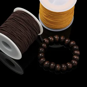 Detalle de cordones elásticos marrones y amarillos con pulsera de cuentas madera