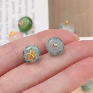 Primo piano macro di bottoni in finta giada con decorazioni di vassoi floreali dorati