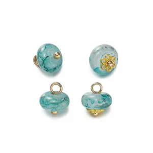 Dettaglio di bottoni in finta giada color verde acqua con decorazioni dorate per fai da te