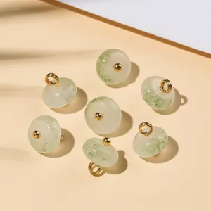 Dettaglio macro di ciondoli vintage in finta giada verde per abbigliamento DIY