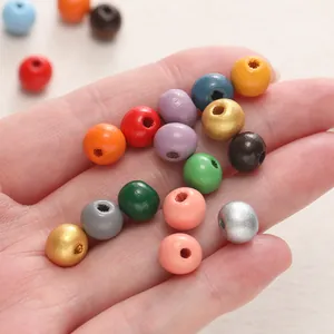 Gedetailleerde close-up van levendige gekleurde houten kralen in de palm van een hand