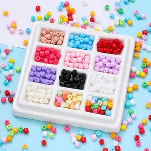 Dettaglio di perline di vetro colorate disposte in un vassoio organizzatore bianco