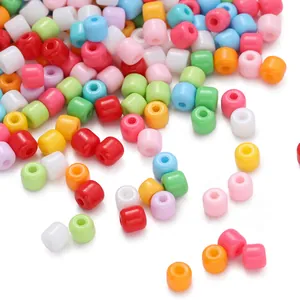 Primo piano di perline cilindriche in vetro dai colori vivaci per creazioni artigianali